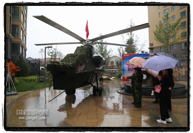 小區(qū)突然出現(xiàn)“飛機坦克”，其中殲15艦載戰(zhàn)斗機一架、99式主戰(zhàn)坦克一輛、武直-10武裝直升機一架，吸引了眾多市民雨中圍觀、合影。